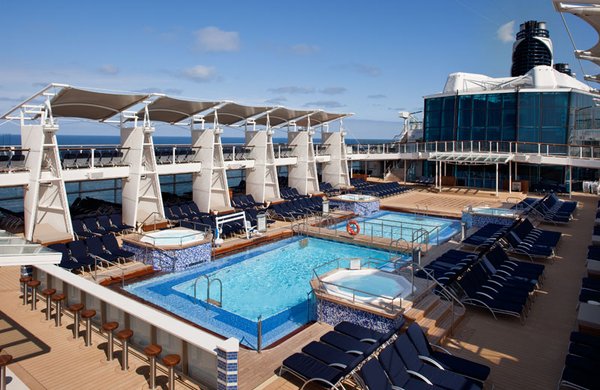 Pooldeck mit vielen Sonnenliegen und einer eigenen Bar